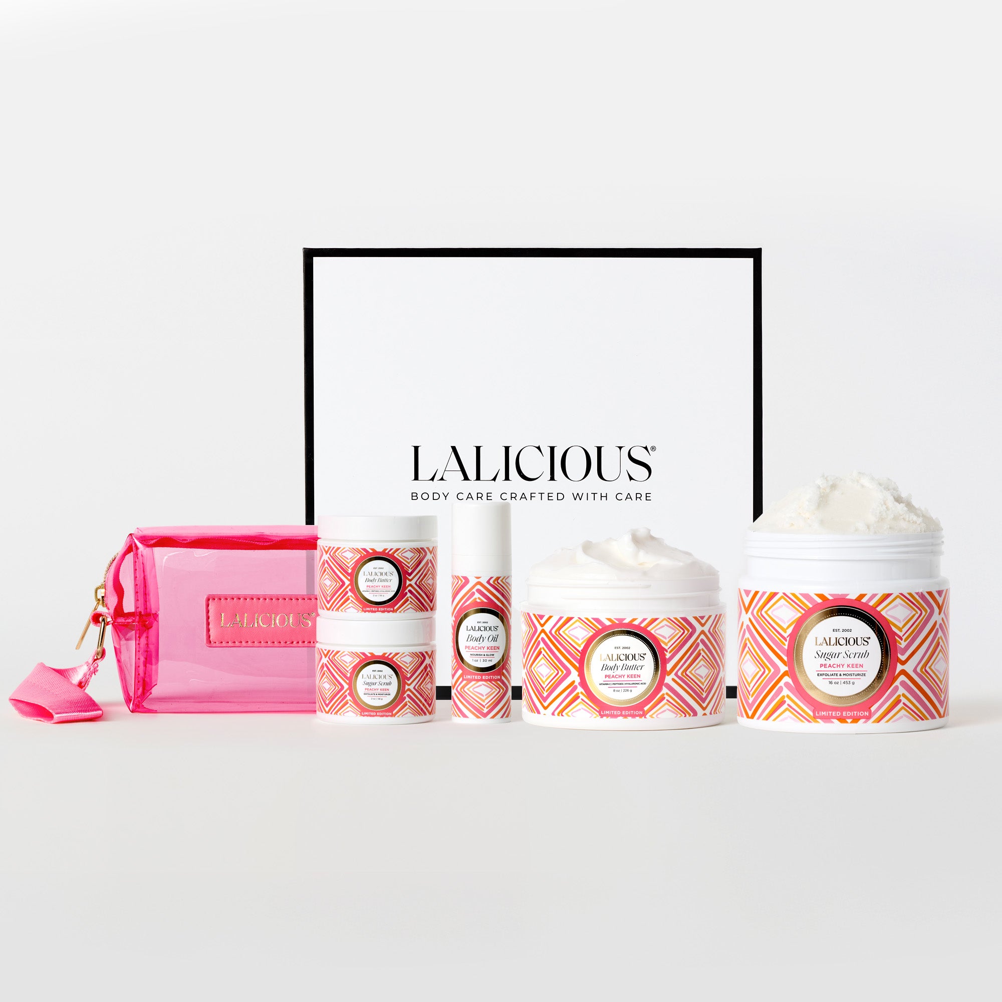 Peachy Keen Collection Box and 2oz body butter, 8oz body butter, 16oz sugar scrub, 2oz sugar scrub, 1oz body oil and pink wristlet on a white background. LALICIOUS