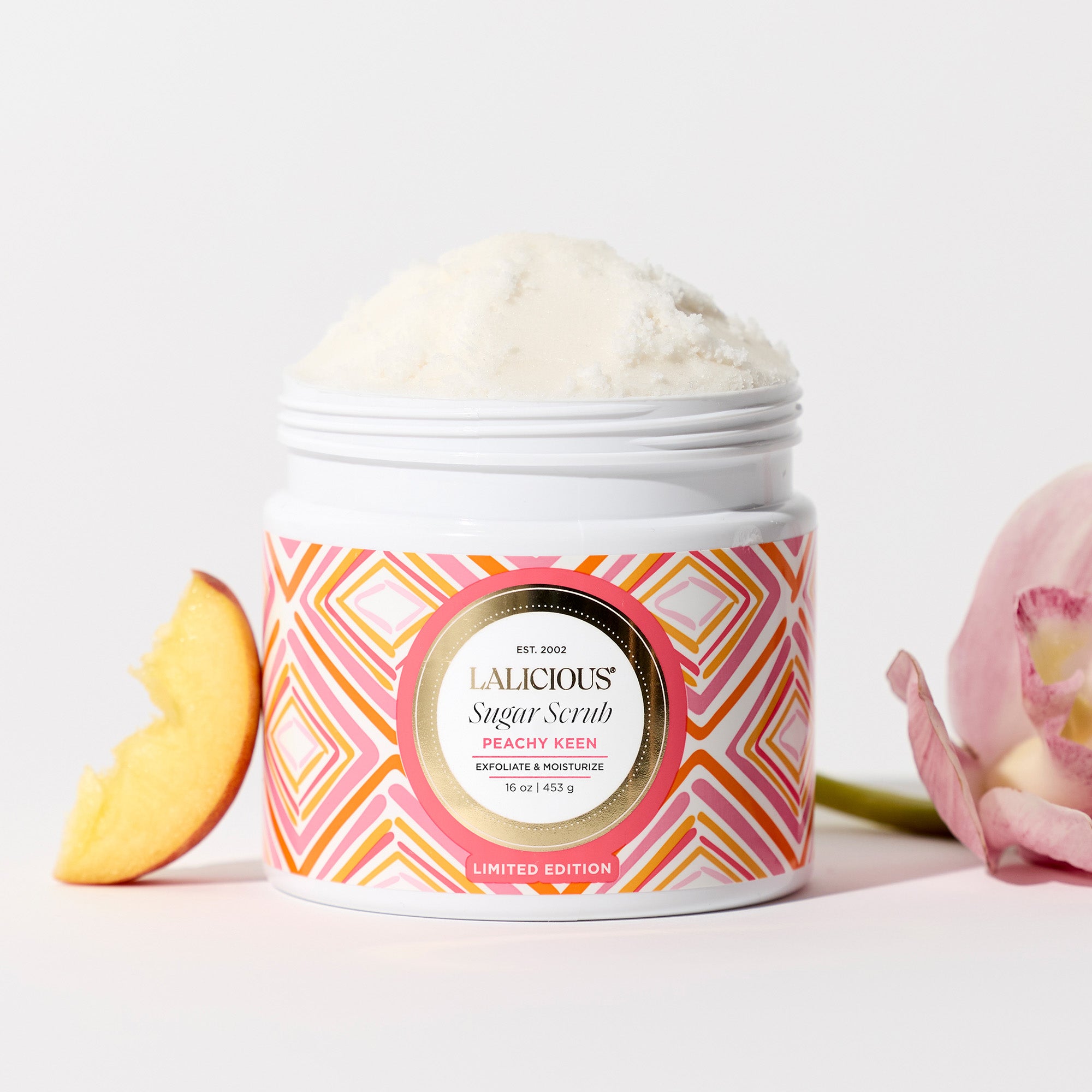Peachy Keen Sugar Scrub without cap with a slice of peach on the side and a flower, on a white background - LALICIOUS