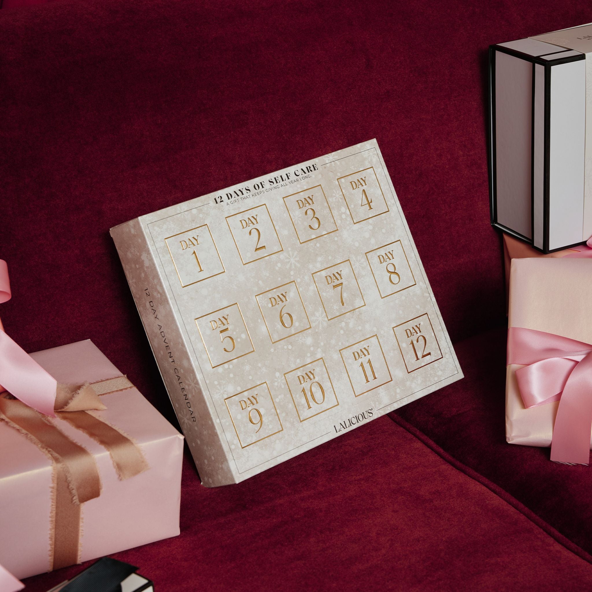 Advent Calendar - LALICIOUS on a red couch with gifts around it.