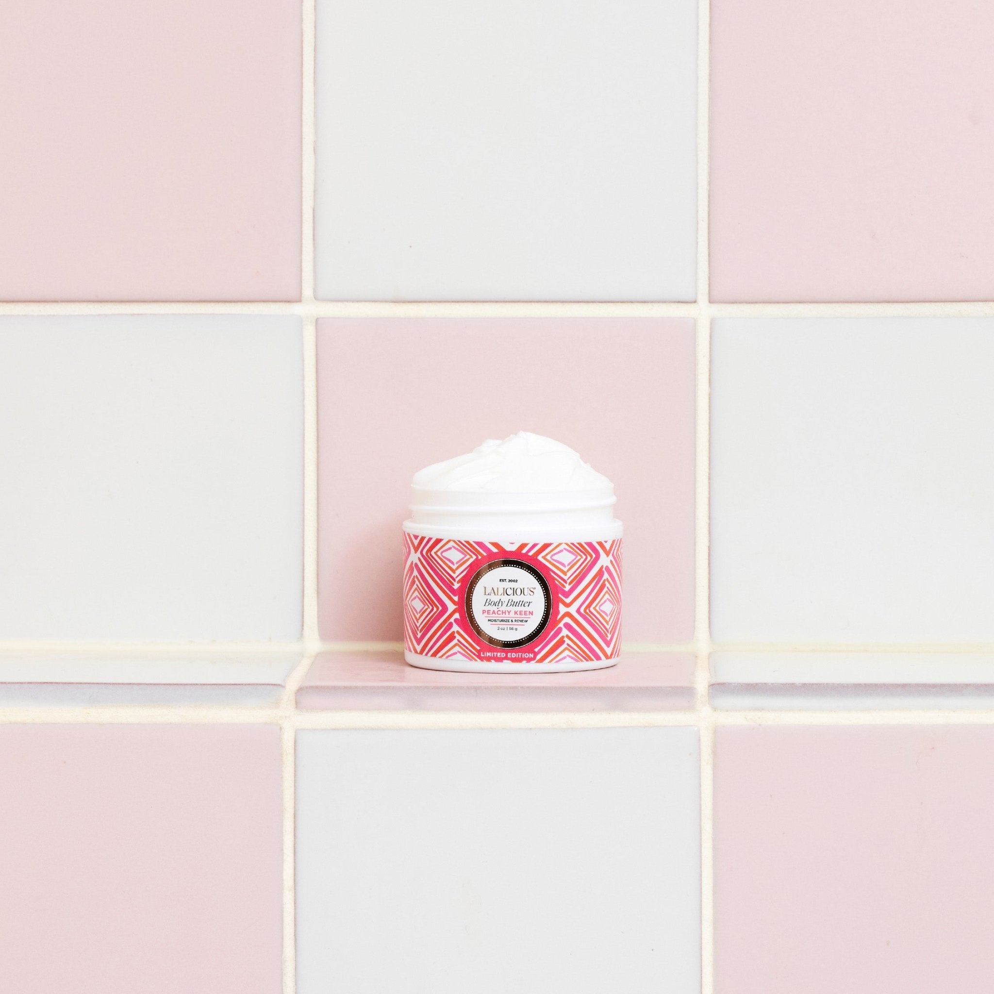 Peachy Keen Travel Set 2 oz Body Butter in the bathroom on a pink and white tiled background.