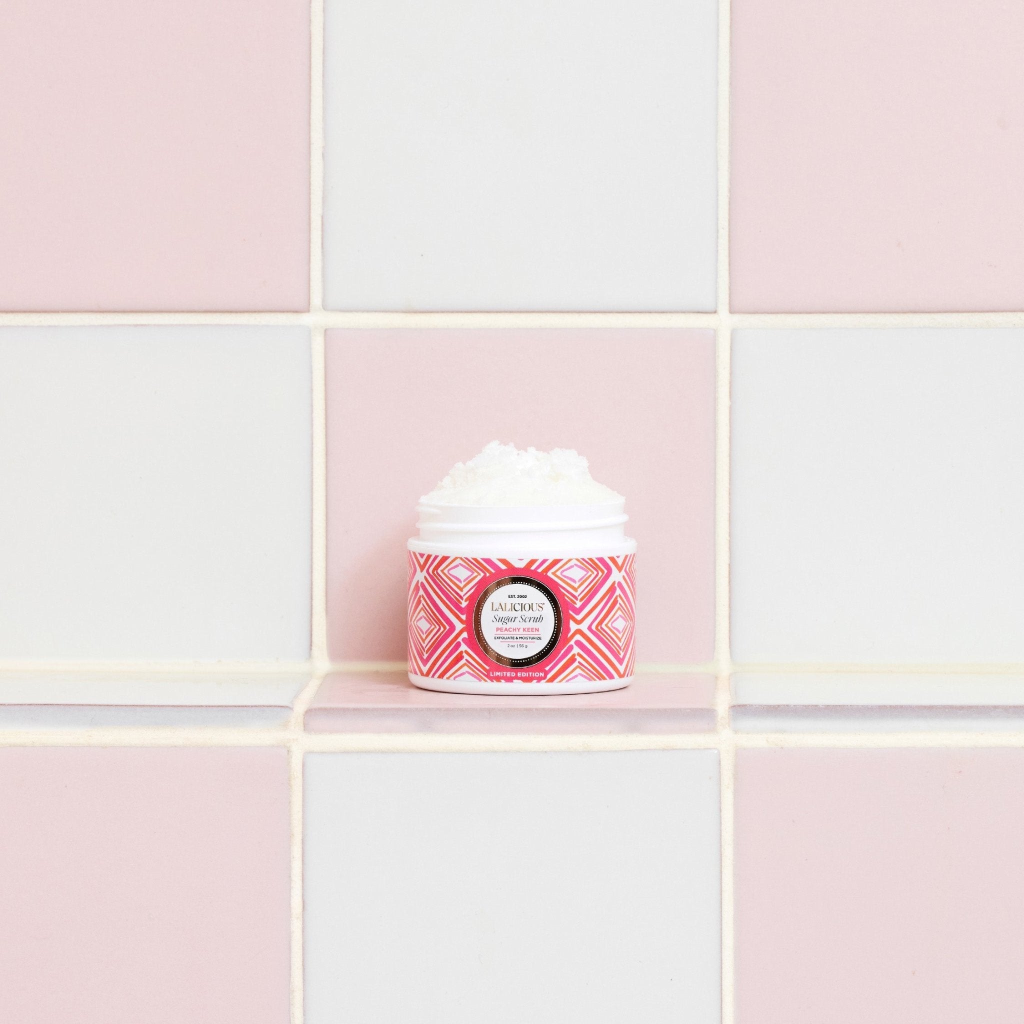 Peachy Keen Travel Set 2oz Sugar Scrub jar in the bathroom on a tiled white and pink background. - LALICIOUS