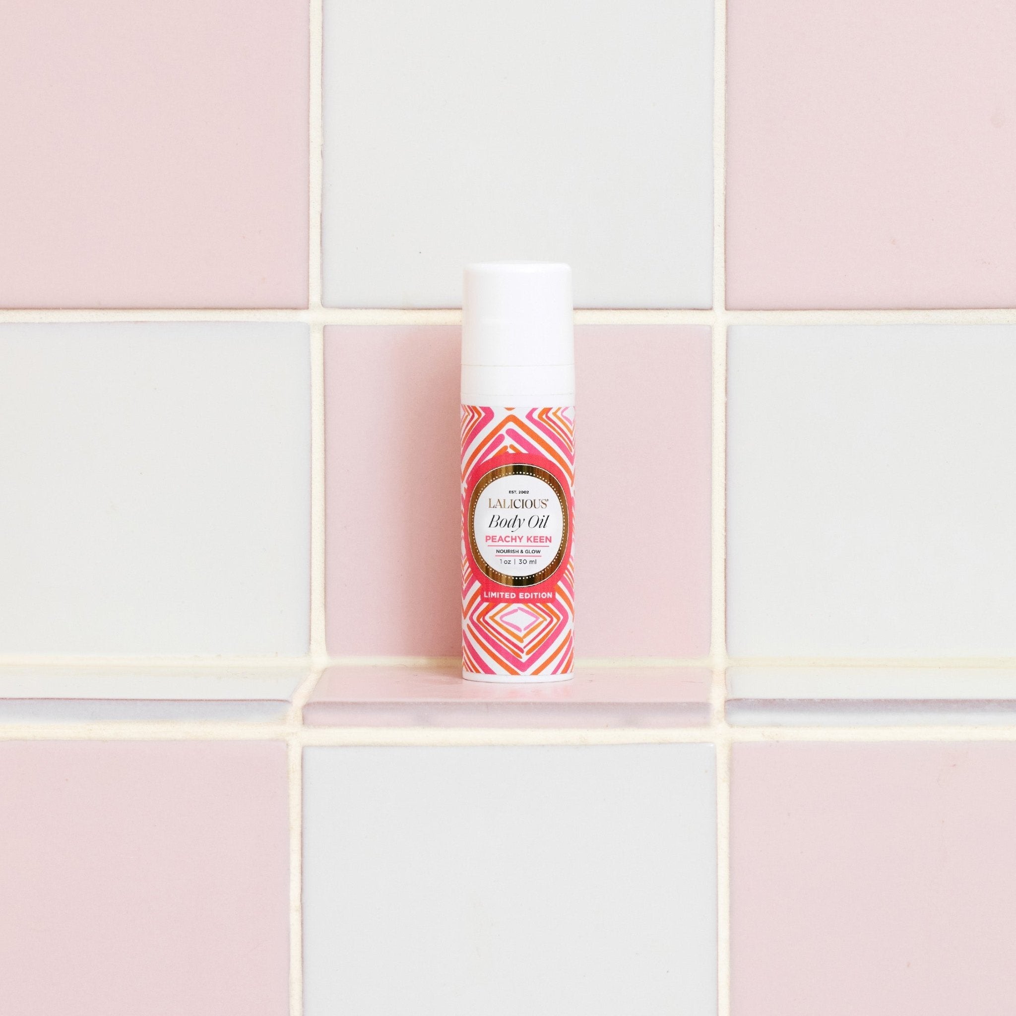 Peachy Keen Travel Set 1oz Body Oil - in the bathroom with a tiled white and pink background. LALICIOUS