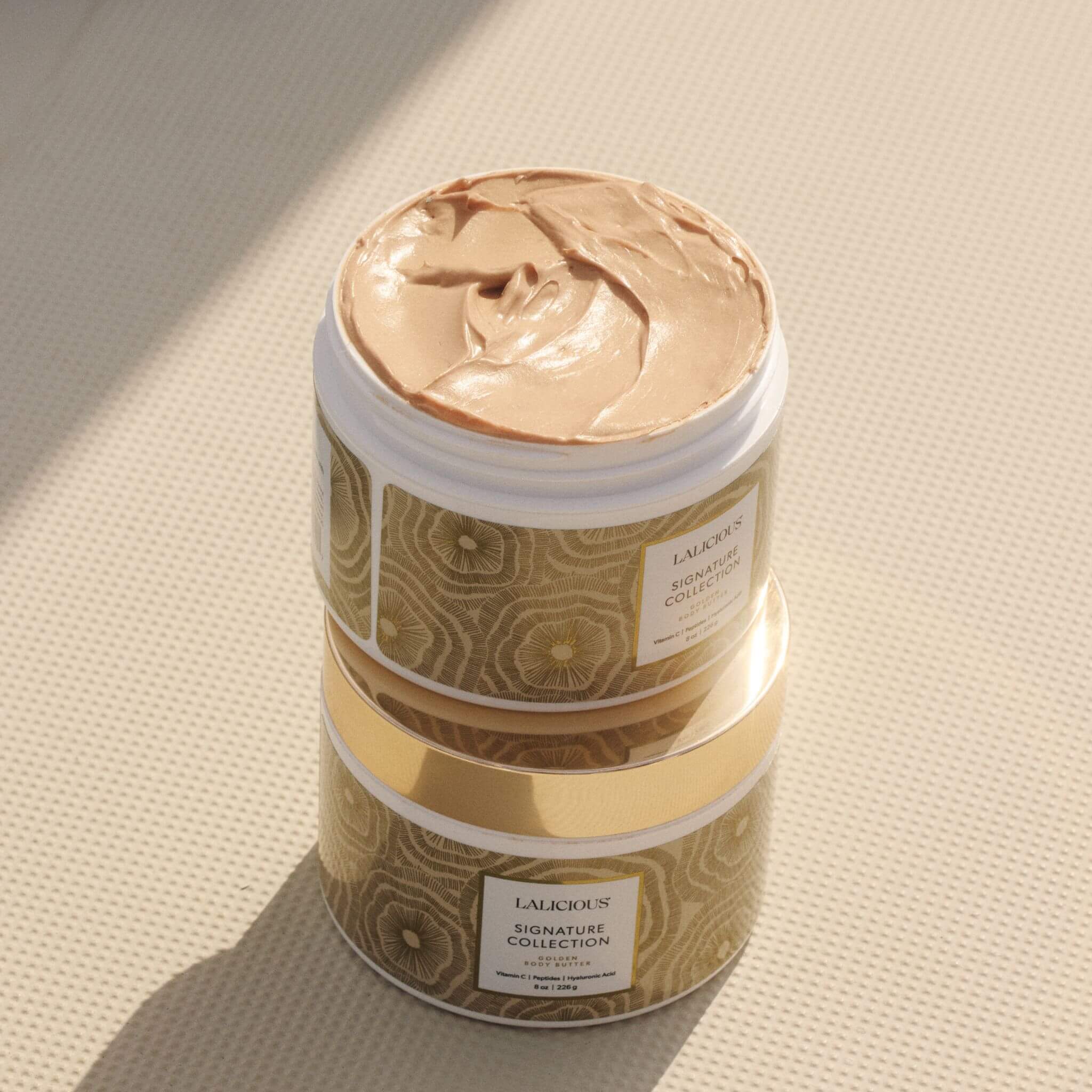 Golden Body Butter one stacked on another one on a bright sunny background - LALICIOUS